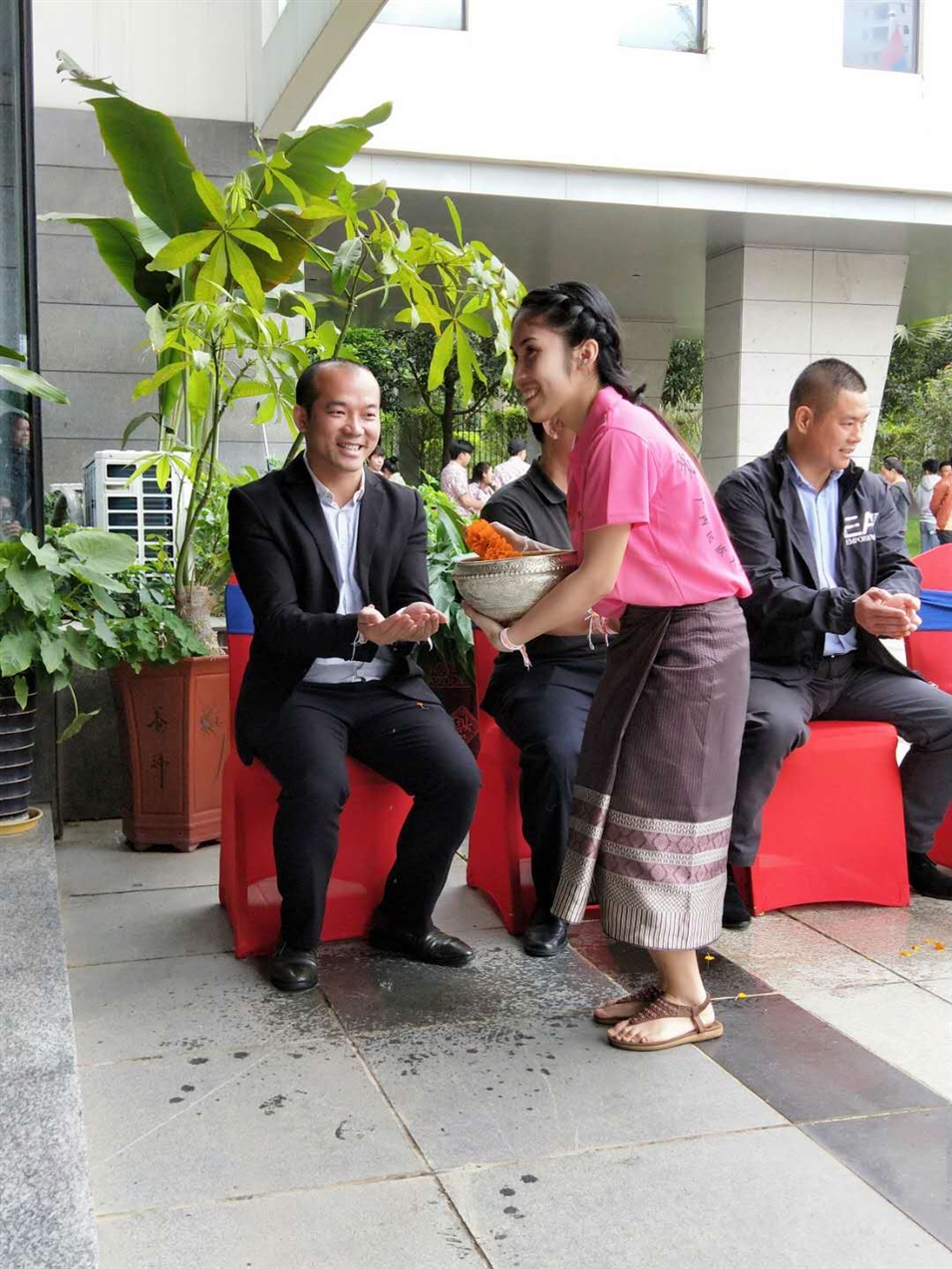 老撾駐廣西留學(xué)生代表將浸有花瓣的香水灑客人的手上，表示對(duì)嘉賓的美好祝福（圖一）